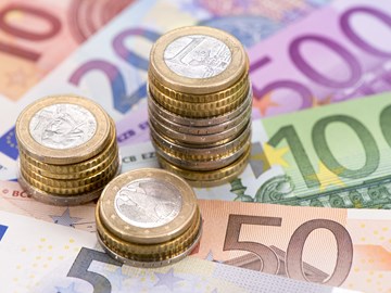 Drei unterschiedlich hohe Stapel aus Euromünzen auf Eurobanknoten - Nahaufnahme Drei unterschiedlich hohe Stapel aus Euromünzen auf Eurobanknoten - Nahaufnahme