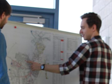 Zwei Personen stehen vor einer Pinnwand für eine Zielnetzplanung Zwei Personen stehen vor einer Pinnwand für eine Zielnetzplanung