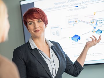 Zwei Frauen im Gespräch bei einer Präsentation, eine Frau trägt kurze rote Haare Zwei Frauen im Gespräch bei einer Präsentation, eine Frau trägt kurze rote Haare