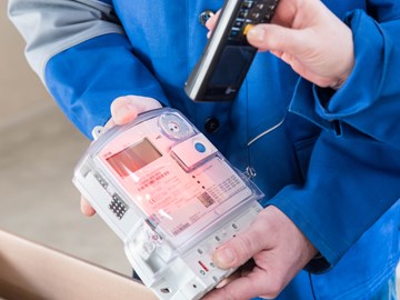 Hände mit Geräten bei der Ablesung eines Stromzählers Hände mit Geräten bei der Ablesung eines Stromzählers