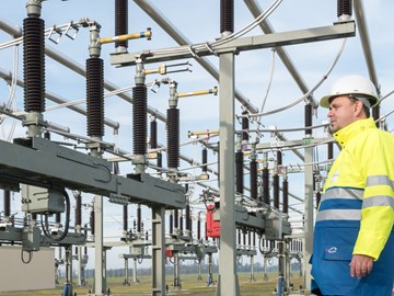 Mitarbeiter mit Helm und Warnschutzjacke an einer Anlage Mitarbeiter mit Helm und Warnschutzjacke an einer Anlage